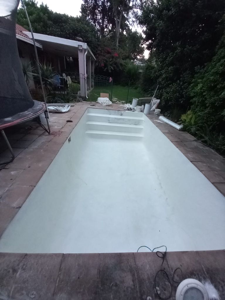 Neglected pool with stained, discoloured surface before renovation